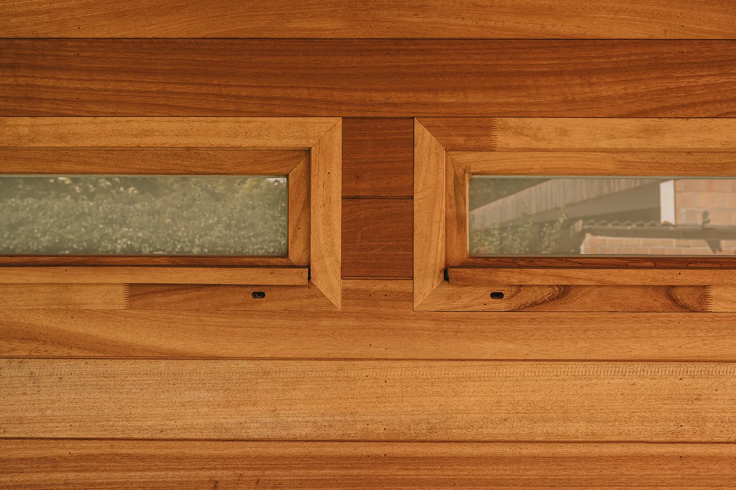 Bardage en bois exotique et menuiseries vitr&eacute;es sur une annexe de maison moderne