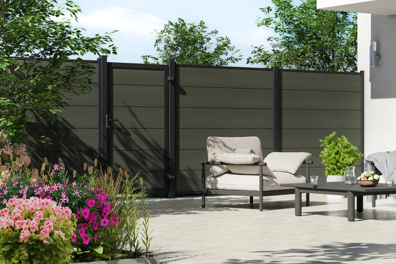 Cl&ocirc;ture en panneaux de bois composite Platinum anthracite avec portillon assorti, autour d&rsquo;une terrasse