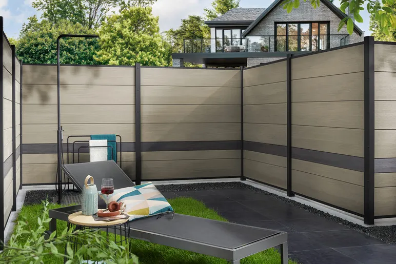 Brise-vue en panneaux de bois composite Platinum gris taupe avec lame d&eacute;corative fonc&eacute;e, autour d&rsquo;une terrasse
