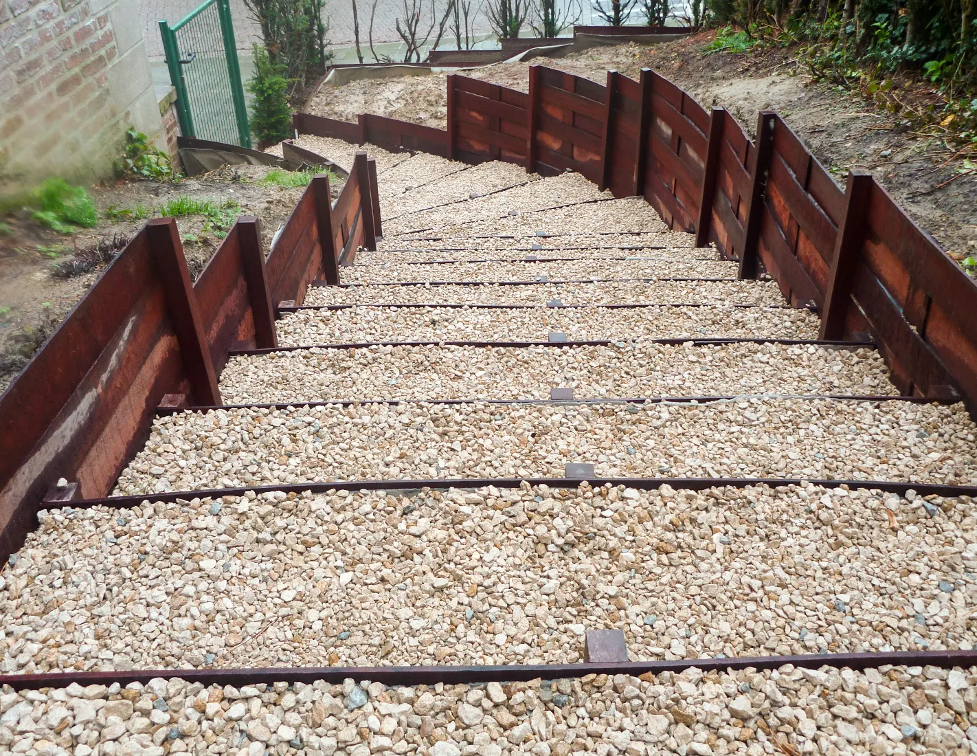 Escalier de jardin &agrave; marches en gravier dont les contremarches et les bordures lat&eacute;rales sont r&eacute;alis&eacute;es en planches d'azob&eacute;