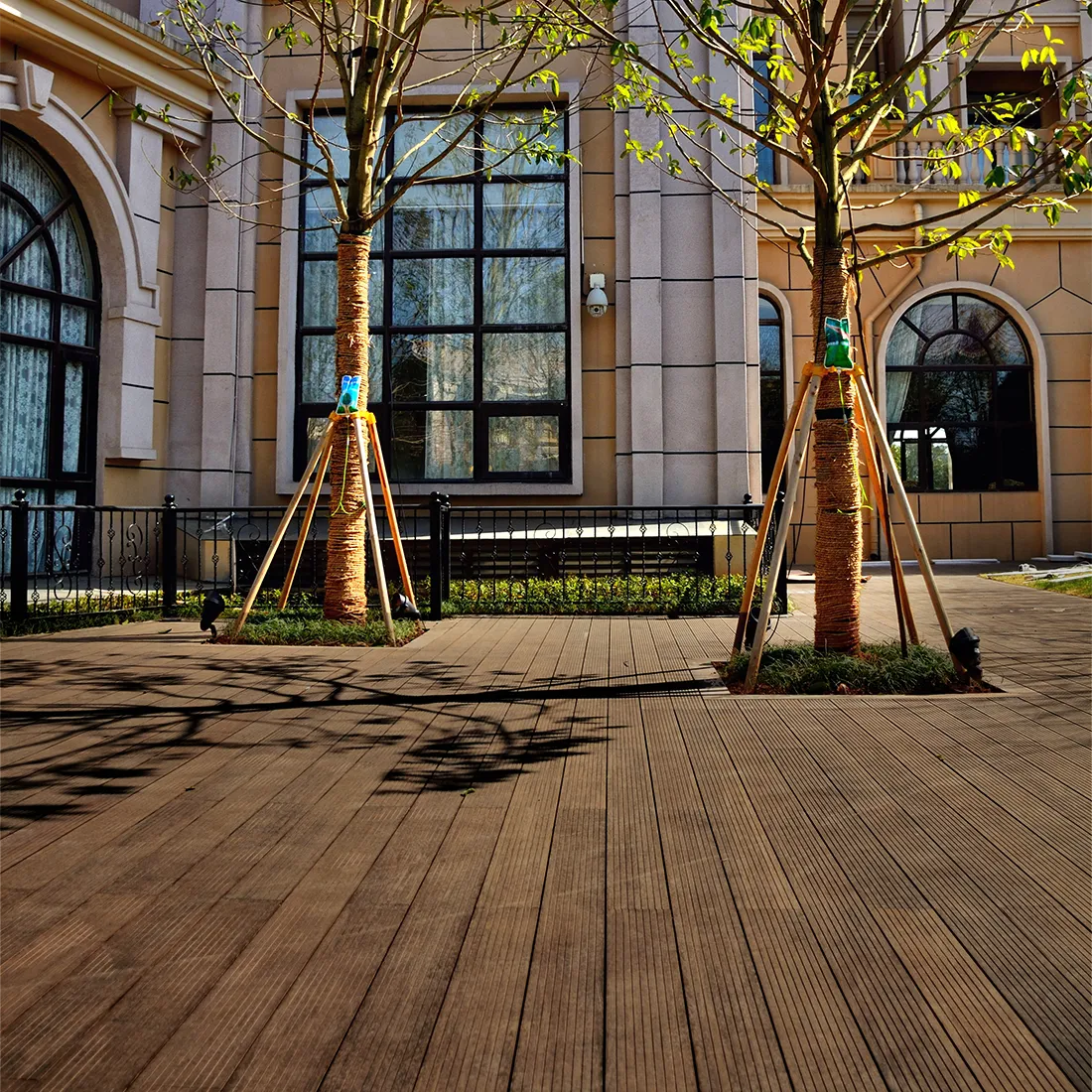 Terrasse ext&eacute;rieure en bambou couleur naturelle devant une maison r&eacute;sidentielle
