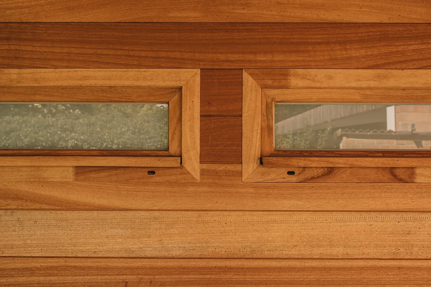 Bekleding van hardhout en glazen schrijnwerk op een bijgebouw van een moderne woning